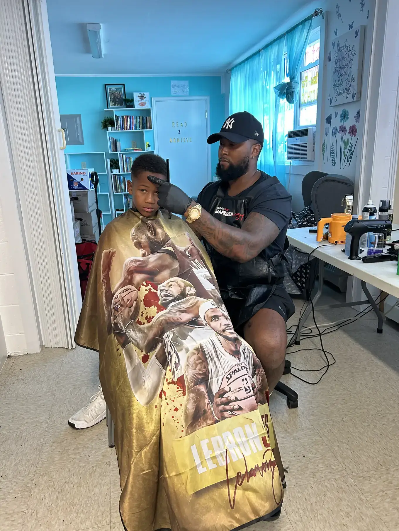 A child in a barber's chair getting their back to school hair cut at Mulgrave Park Caring and Learning Center