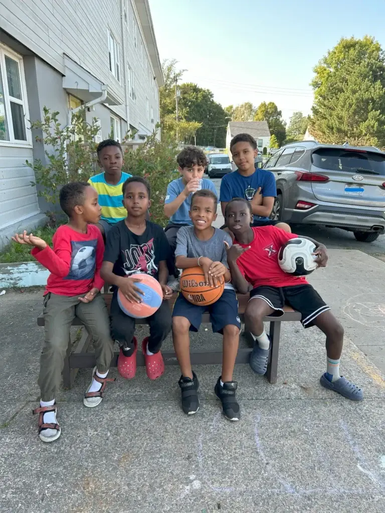 Kids at the Mulgrave Park in a group photo with some of them holding either a basketball or football